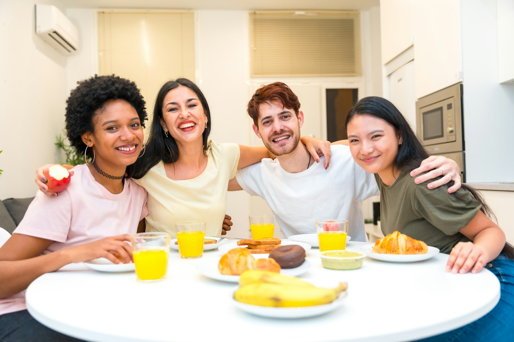 Portrait of multi-ethnic friends sitting on a breakfast table